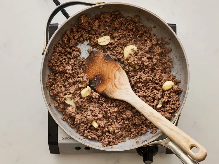 Add the crushed garlic, grated ginger, and sesame oil to the skillet