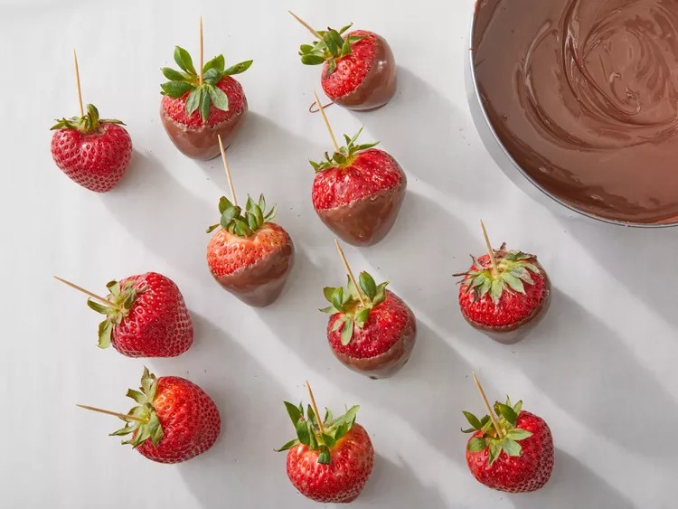 Insert a toothpick into the top of each strawberry at the stem end. Hold the strawberry by the toothpick and dip it into the melted chocolate. Turn it slightly to coat evenly.