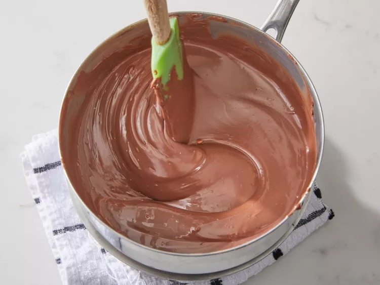 In a double boiler, melt the milk chocolate chips and shortening together. Stir occasionally until the mixture is smooth and fully melted. Keep the heat gentle.