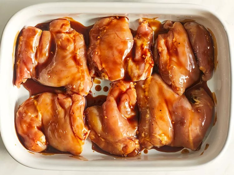 Place the chicken thighs in the prepared baking dish. Brush both sides of each piece with the teriyaki sauce. Save any extra sauce for later basting.