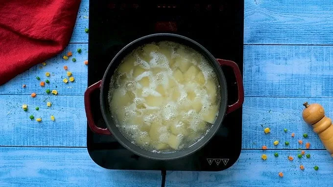 Place the peeled and cubed potatoes in a large pot. Cover them with water. Bring to a boil, then reduce to a simmer. Cook for 10 to 15 minutes, until the potatoes are fork tender.