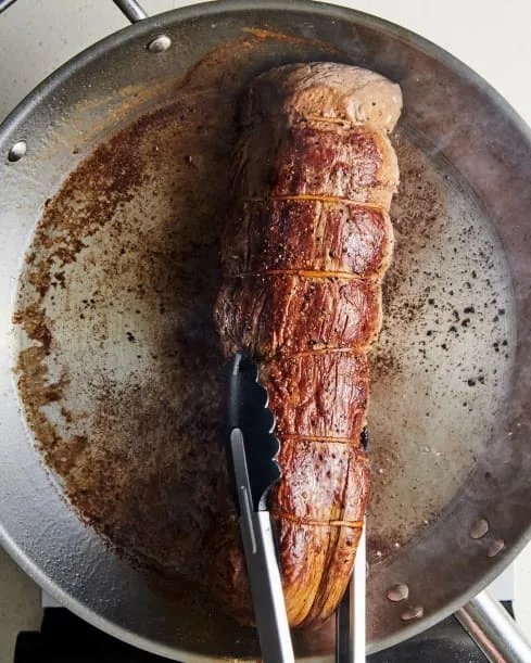 Heat the vegetable oil in a large frying pan over medium-high heat. When hot, add the roast and sear on all sides, turning occasionally, until browned all over, about 8 minutes total. Transfer to a plate and refrigerate.