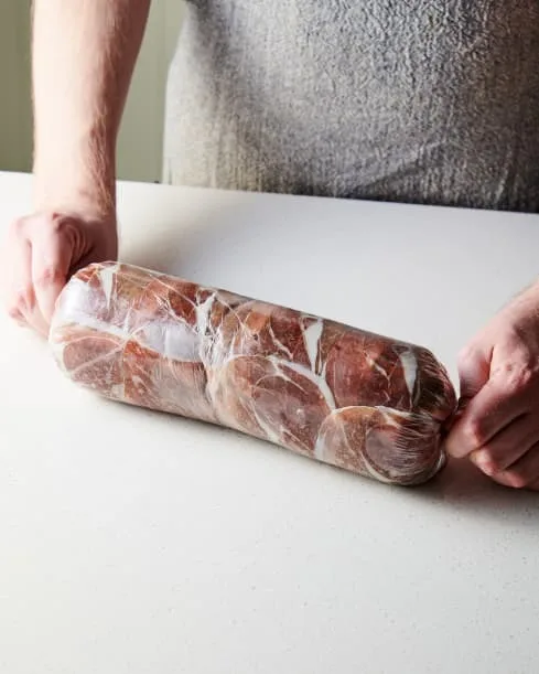 Rewrap tightly in the plastic wrap, twisting the ends to secure. Roll it gently on the counter to tighten. Knot or tie the ends and refrigerate for at least 30 minutes or up to 8 hours.