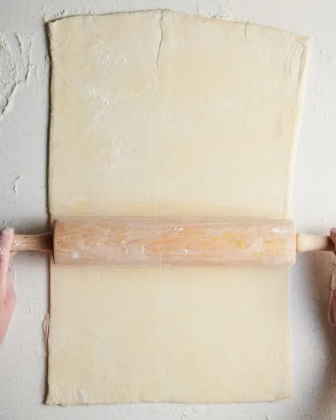 Lightly dust your work surface with flour. Unfold the puff pastry. If it comes in two sheets, place one above the other and pinch together to form one sheet. Roll from side to side into a rectangle 6 to 8 inches wider than the roast.