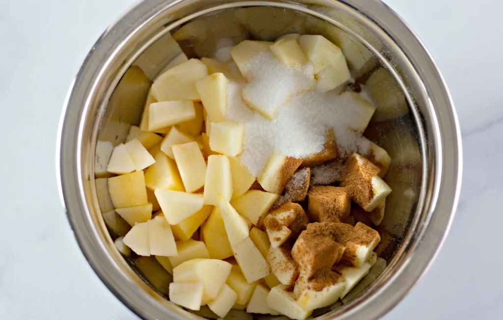 In a small bowl, mix the chopped apples with cinnamon and sugar. Spoon half of the apple mixture over the batter. Add the remaining batter on top and spread it gently. Finish with the rest of the apples, pressing them down slightly into the batter.
