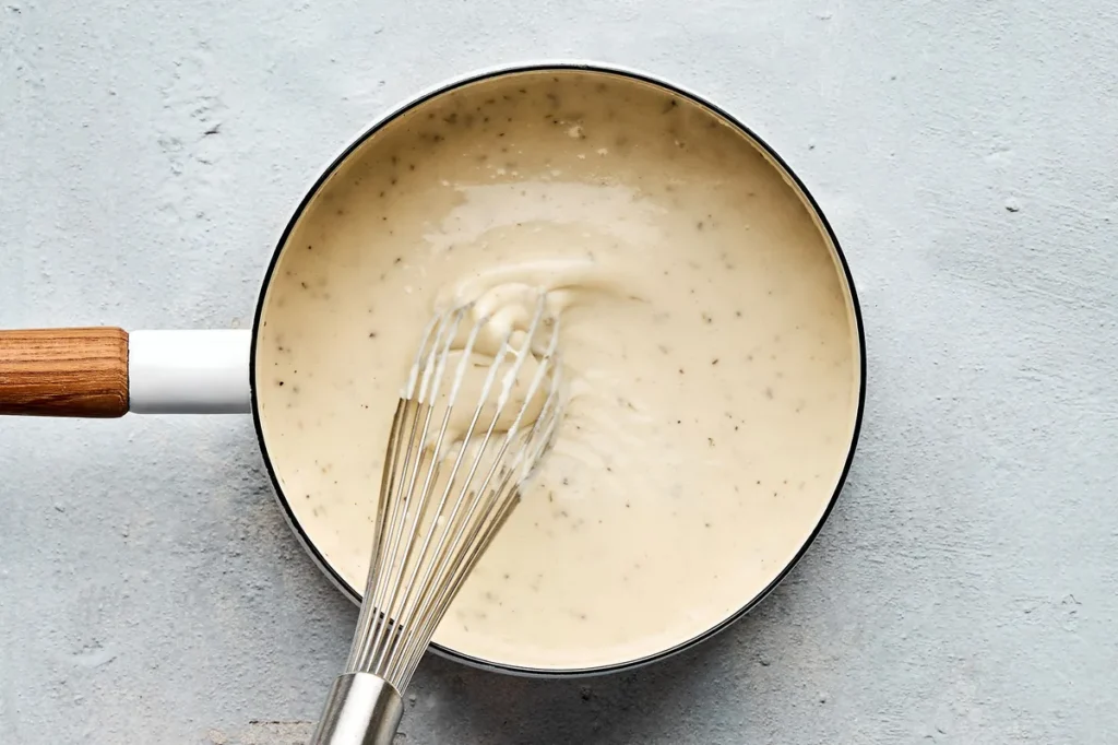 Once the butter is melted, increase the heat slightly and whisk in the flour mixture. Cook while whisking until it begins to simmer. Lower the heat to medium and slowly whisk in the remaining chicken stock, milk, garlic powder, thyme, salt, and pepper. Continue whisking until the gravy thickens. Taste and adjust the seasoning if needed.