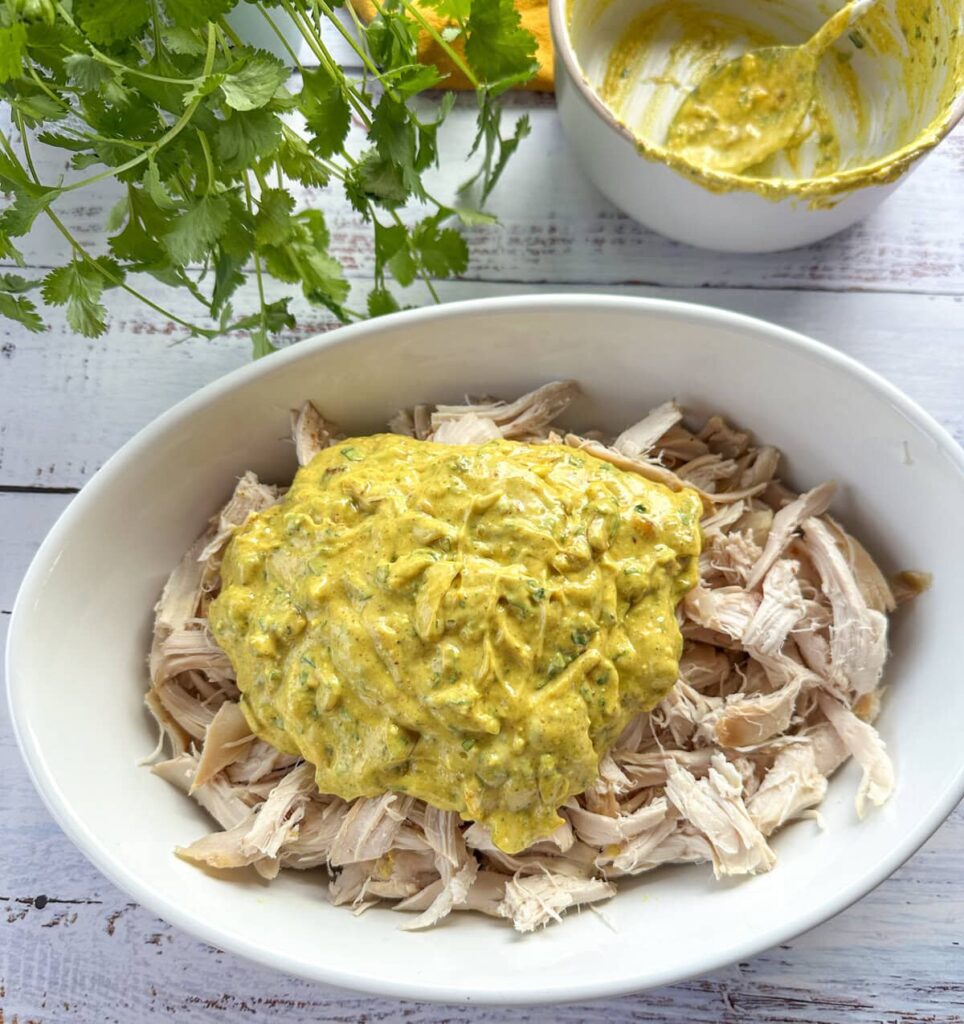 Shred or dice the cold cooked chicken into 2–3 cm pieces. Add the chicken to the bowl and gently stir until all the pieces are well coated in the sauce.
