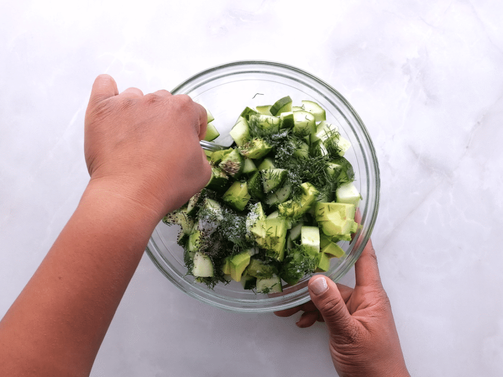 Make the cucumber salad. In a medium bowl, combine the cucumbers, avocado, lemon juice, dill, and a pinch of salt and pepper. Toss gently to mix. Add the avocado just before serving so it stays fresh.