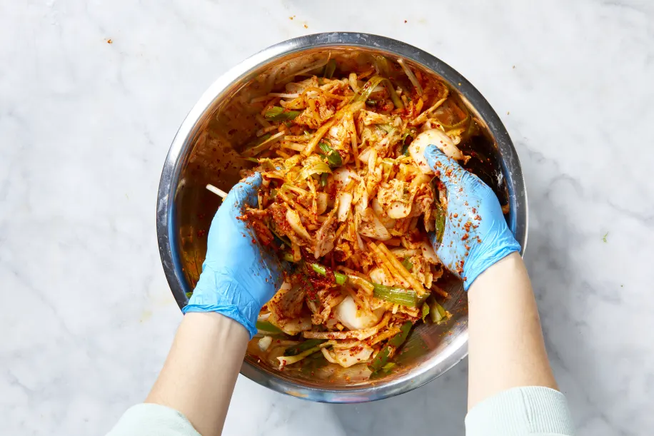 Using your hands, mix everything together until the vegetables are fully coated with the paste. Wearing gloves helps protect your hands from the spice.