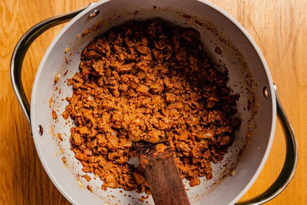 Stir in the chili powder, dried oregano, and sugar. Cook for 2 minutes to let the spices bloom.