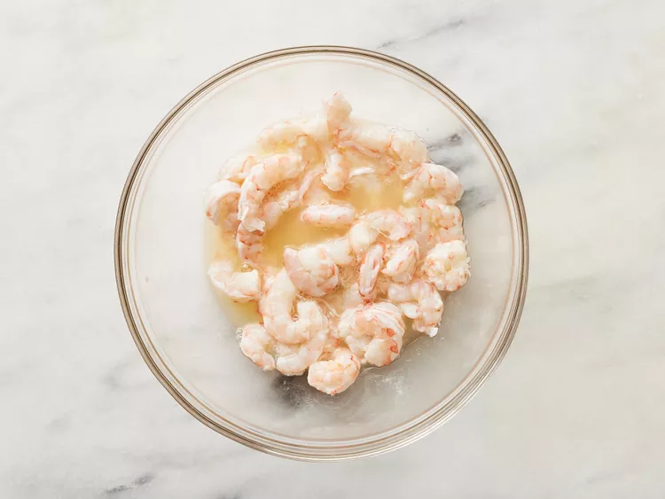 Place the shrimp in a bowl. You can chop them into smaller pieces or leave them whole, depending on your preference. Pour the lemon juice over the shrimp, making sure they are fully covered. Cover and refrigerate for about 30 minutes, until the shrimp turn opaque and slightly firm.