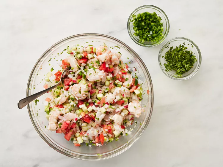 Add the chopped onions, tomato, cucumber, radishes, and minced garlic to the bowl. Toss gently to combine.