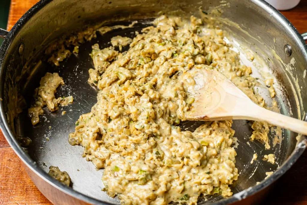 Sprinkle in the reserved seasoned flour and stir well, then add the broth concentrate and gradually whisk in milk followed by water until a smooth sauce forms.