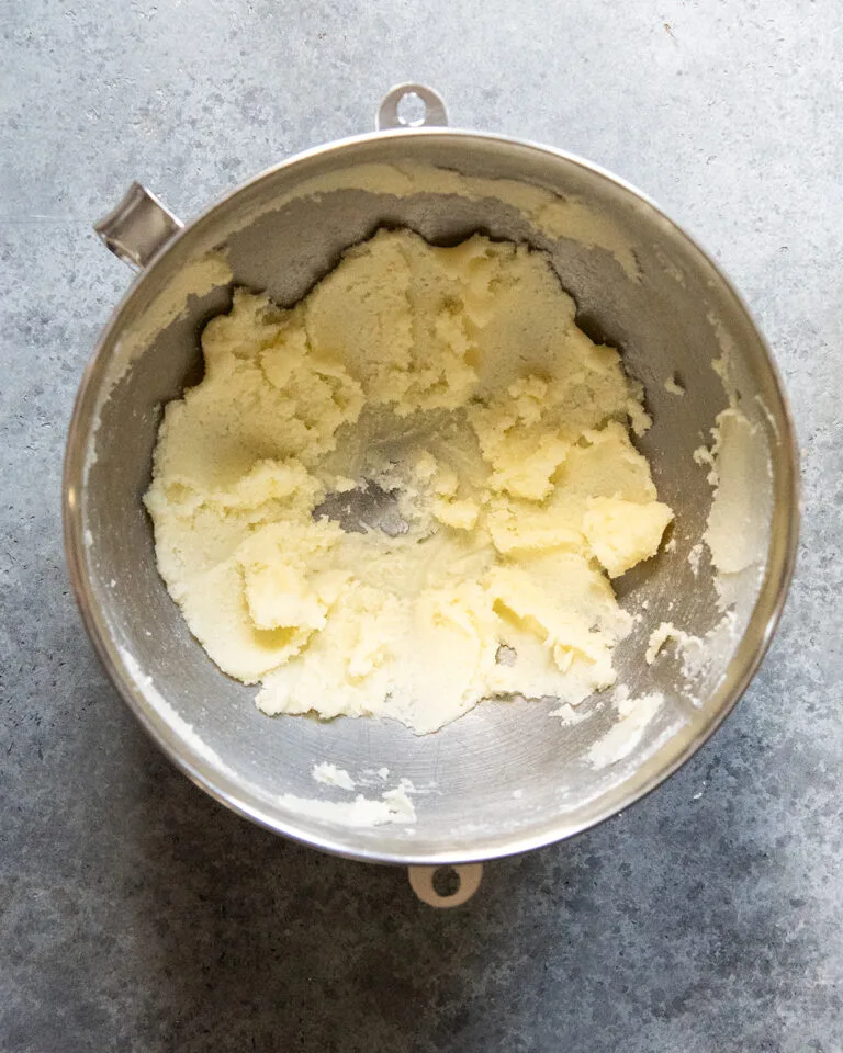 Beat the softened butter and sugar together in a large bowl for about 2 minutes until the mixture becomes light, fluffy, and creamy.