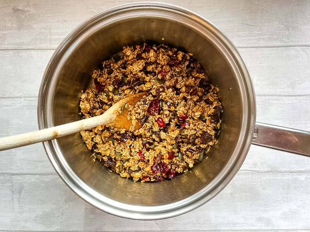 Stir in the granola along with the nuts and dried fruits, mixing well so everything is evenly coated.