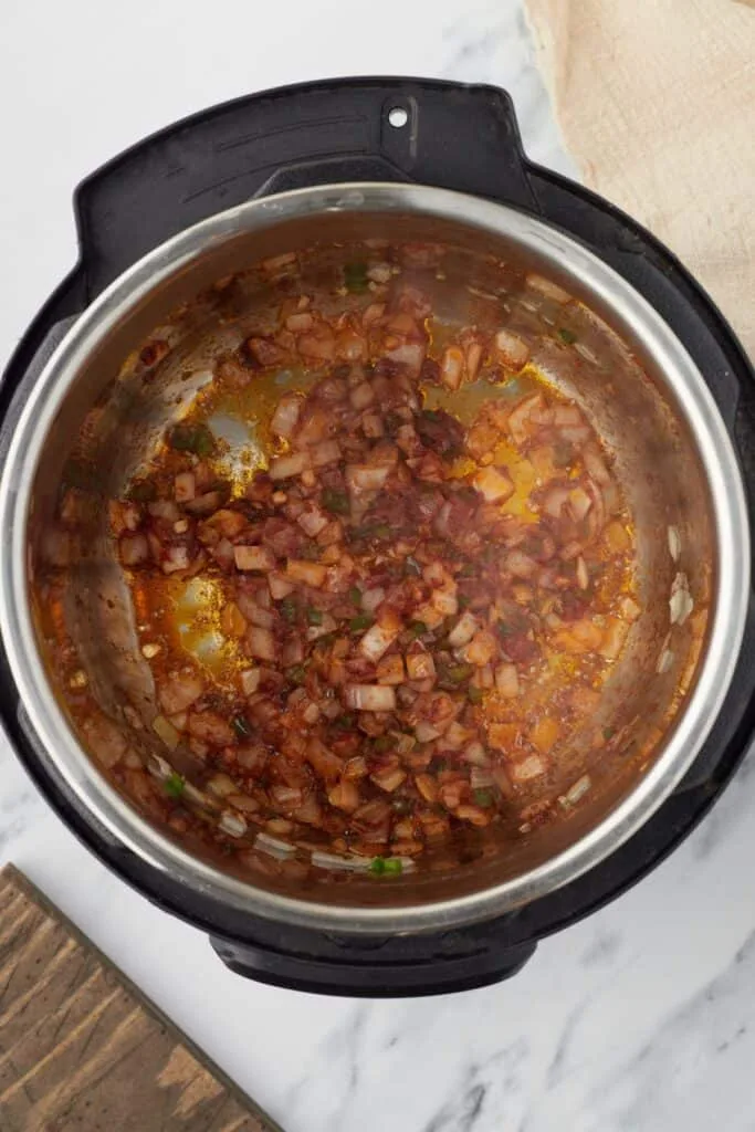 Stir in the tomato paste, chili powder, cumin, and salt, mixing continuously until the paste blends in and the spices become fragrant.