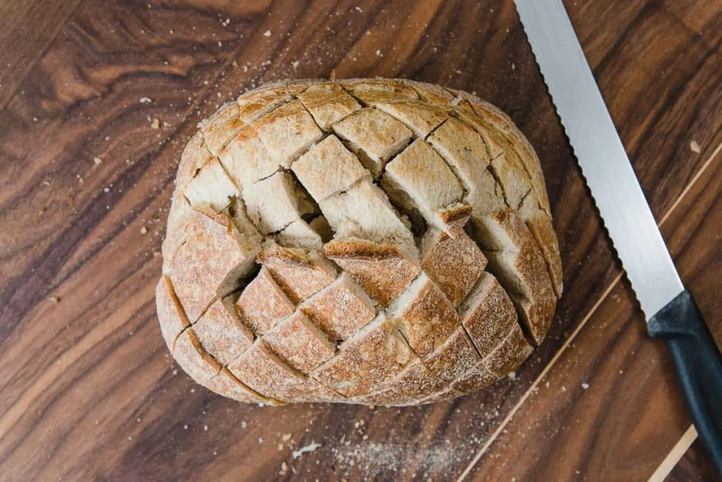 Use a serrated knife to cut the bread diagonally into slices without cutting all the way through, then turn and repeat to create a grid pattern.