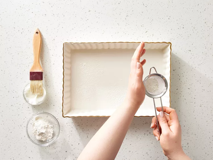 Preheat the oven and grease a 9x13-inch baking dish well so the cake releases easily after baking.