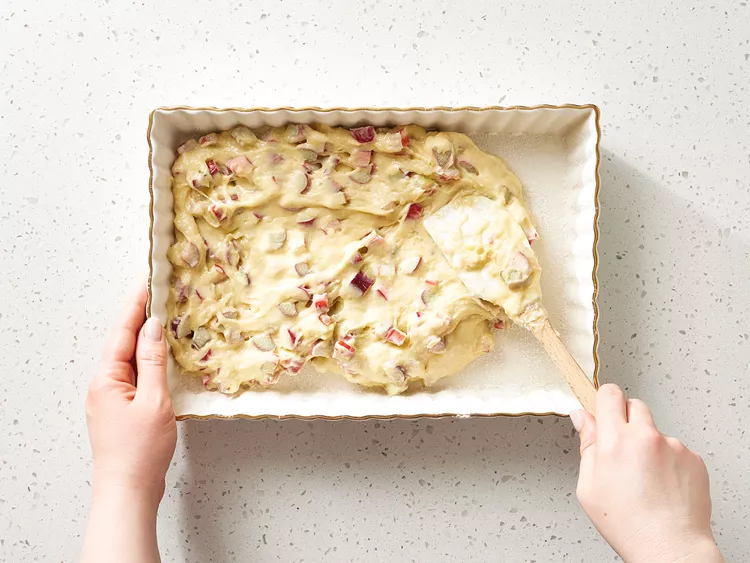 Fold the diced rhubarb into the batter carefully so it is evenly distributed without overmixing.