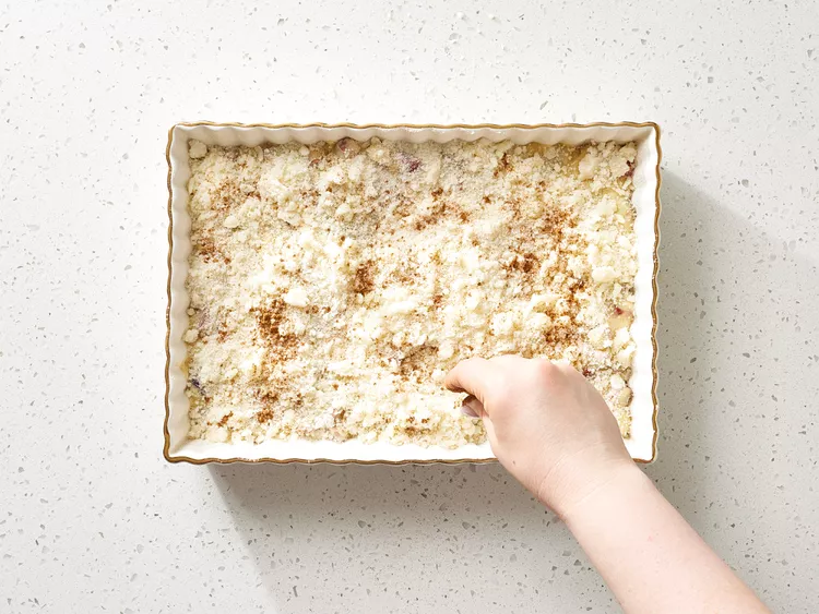 Sprinkle the streusel mixture evenly over the cake batter and lightly dust the top with cinnamon.