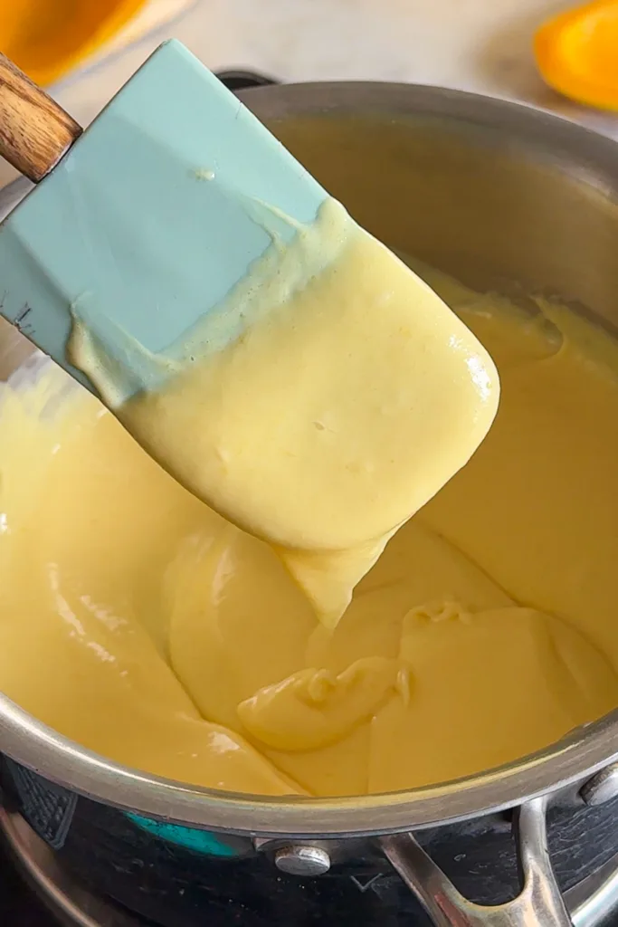 Remove the saucepan from the heat and immediately stir in the lemon juice, allowing the mixture to begin thickening as it cools into a smooth, creamy consistency.
