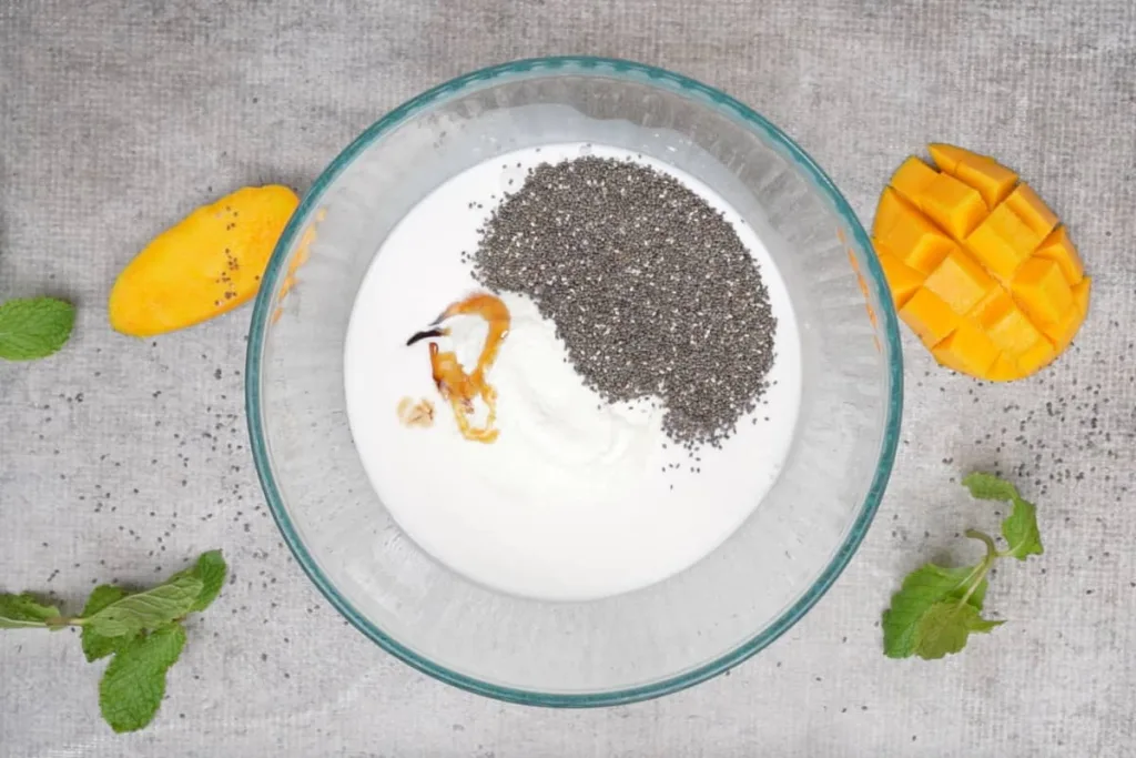 Combine the coconut milk, yogurt, chia seeds, honey, and vanilla extract in a large mixing bowl, stirring well until everything is fully blended and smooth.