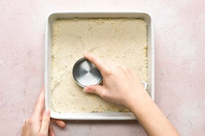 Reserve part of the crumb mixture for the topping and firmly press the remaining mixture into the bottom of a greased baking pan.