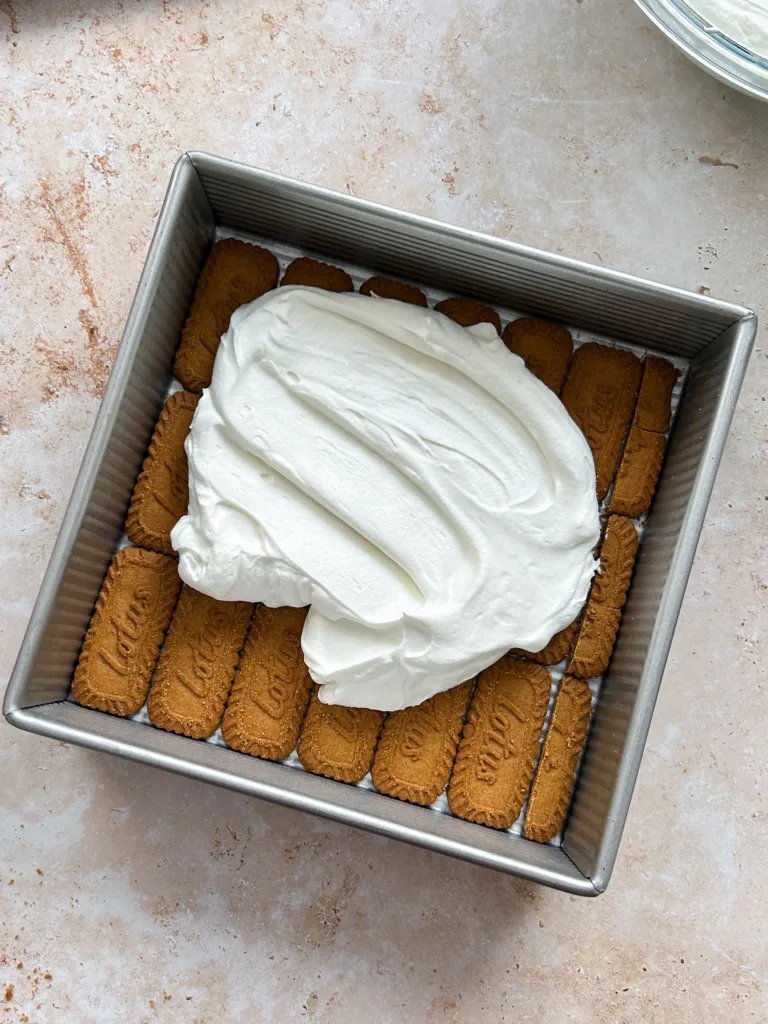 Repeat the layering process with another layer of cookies, cream, and mangoes, keeping the layers even for a consistent texture.