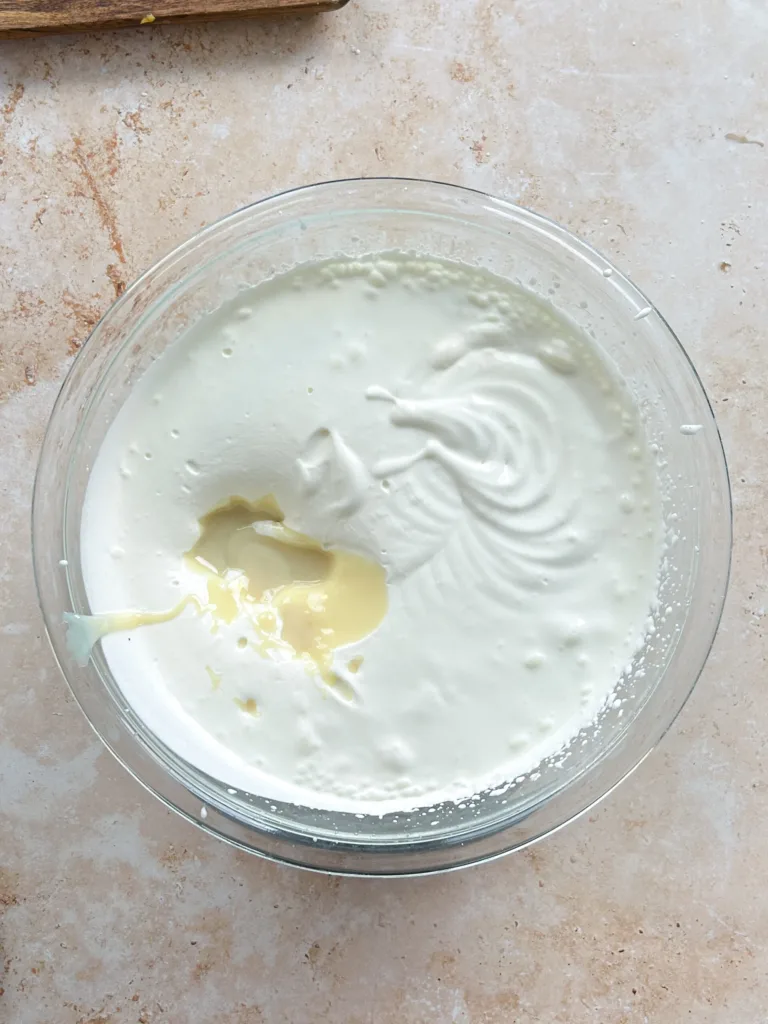 Add the chilled heavy cream to a large bowl and whisk on medium speed until it thickens to a soft, ribbony consistency without reaching stiff peaks.