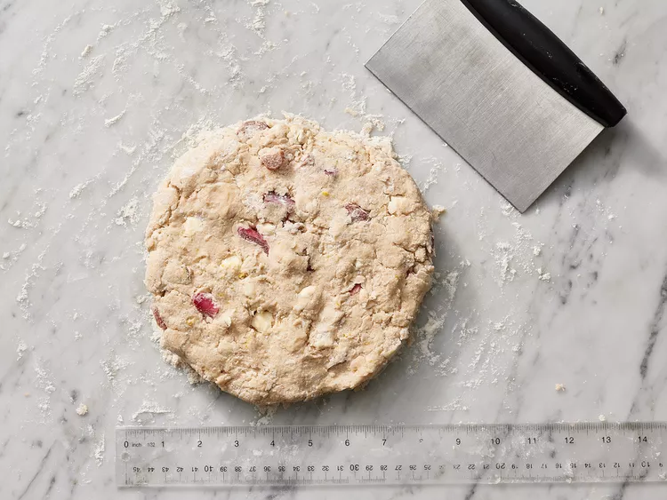 Turn the dough onto a lightly floured surface and gently press it into an even round shape about 8 inches wide.