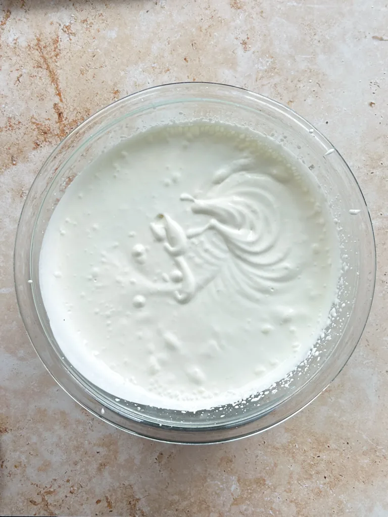 Add the chilled heavy cream to a large bowl and whisk on medium speed until it thickens to a soft, ribbony consistency without reaching stiff peaks.